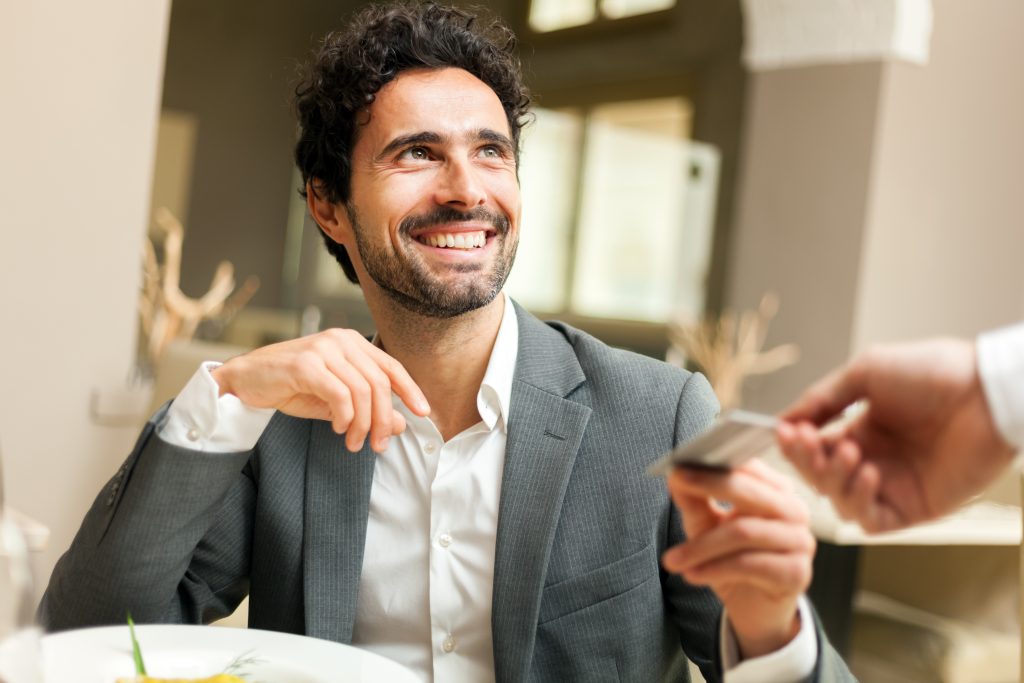Small business owner managing multi-currency expenses on mobile device